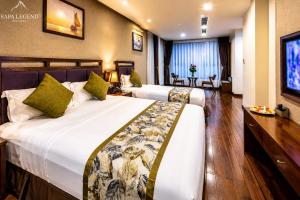 a hotel room with two beds and a television at Canvas Sapa Legend Hotel in Sapa