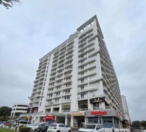 a large white building with cars parked in a parking lot at The Origin Suites opposite Hyatt Dlf my pad Lucknow in Lucknow