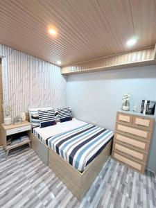 a bedroom with a bed and a wooden ceiling at Casa De Jumeirah in Bacolod