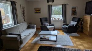 a living room with a couch and two chairs and a table at Lapland Snow Cabin in Masugnsbyn