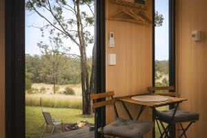 a room with a table and chairs and a window at One Gaea by Tiny Away in Rainbow Flat