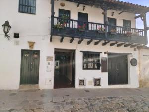 a white building with a balcony and two doors at Hotel Alma Divina in Villa de Leyva