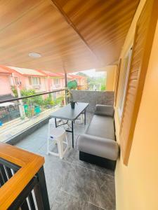 a room with a couch and a table on a balcony at Casa De Jumeirah in Bacolod
