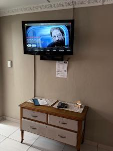 a flat screen tv hanging on a wall at Evening Star Guest Units in Fichardtpark