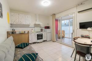 a living room with a couch and a kitchen at Maison venitia t2 in Aussonne