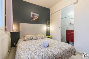 a bedroom with a bed with a white comforter at Maison venitia t2 in Aussonne
