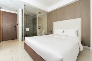 a bedroom with a large white bed and a shower at Nicecy Ben Thanh Hotel in Ho Chi Minh City +21 photos