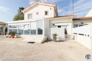 a white house with a lot of windows at Maison venitia t1 in Aussonne