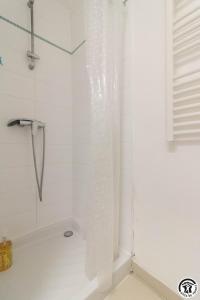 a shower with a plastic shower curtain in a bathroom at Maison venitia t1 in Aussonne