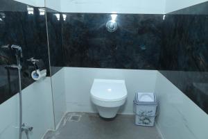 a bathroom with a toilet and a glass shower at Hotel Shreyash in Solapur +20 photos