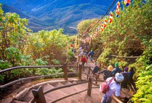 a group of people walking up a mountain path at Misty Garden in Maskeliya