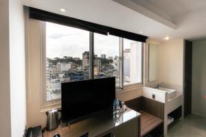 a living room with a large window with a flat screen tv at Nicecy Ben Thanh Hotel in Ho Chi Minh City