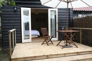 a wooden deck with a table and an umbrella at Fox Inn in Darsham