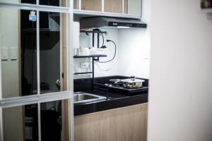 a small kitchen with a sink and a stove at The Nook at Park in Ibaba +1 photo