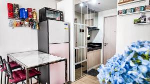 a kitchen with a refrigerator and a table at The Nook at Park in Ibaba