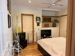 a bedroom with a bed and a flat screen tv at Bethel Homestay in Watsonia North