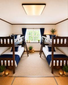 two bunk beds in a room with a window at ペンションハートウォーマー in Myoko