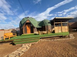 a small house with a green roof on a field at Espiritu Domo Lodge in Coinco