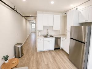 a kitchen with white cabinets and a stainless steel refrigerator at The Oak & Aura Retreat in St. Charles +2 photos