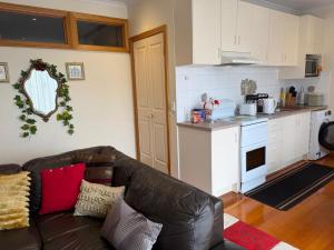 a living room with a couch and a kitchen at Bethel Homestay in Watsonia North