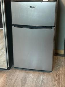 a silver refrigerator in a room with a wooden floor at Alvin Relax in El Cajon