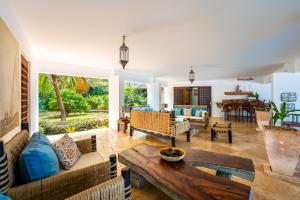 a living room with a couch and a table at Tequila Sunrise Beach Villa-Diani Beach in Diani Beach
