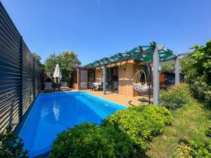 a swimming pool with a pergola and a house at Egem Tatil Evleri in Fethiye