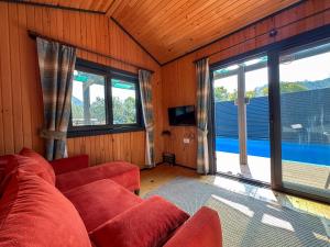 a living room with a red couch and two windows at Egem Tatil Evleri in Fethiye