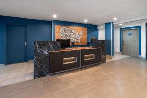 an office with blue walls and a desk with a computer at Microtel Inn & Suites by Wyndham Denver Airport in Montbello