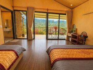 a bedroom with two beds and a balcony with a view at Stilla Home in Tả Van +3 photos
