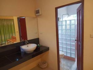 a bathroom with a sink and a toilet and a mirror at Raisubsomboon Resort in Ban Don Wan +122 photos