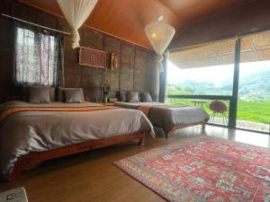 a bedroom with two beds and a large window at Stilla Home in Tả Van