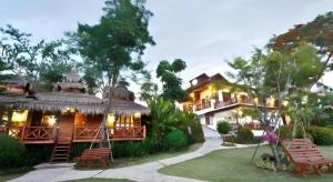 a large house with benches in front of it at Gin's Greenery Resort in Ban Hua Wiang