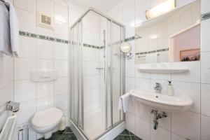 a bathroom with a shower and a toilet and a sink at Pension Posauner in Dorfgastein +30 photos