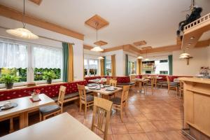 a restaurant with tables and chairs and windows at Pension Posauner in Dorfgastein