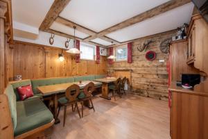 a restaurant with wooden walls and tables and chairs at Pension Posauner in Dorfgastein