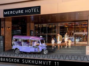 a small purple vehicle parked outside of a building at Mercure Bangkok Sukhumvit 11 in Bangkok