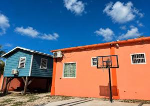 an orange and blue building with a basketball hoop at Lily's Sunrise Villa in Ladyville