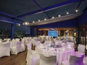 a banquet hall with white tables and white chairs at Ibis Saigon Airport in Ho Chi Minh City +101 photos