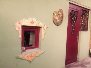 a mirror on a wall next to a purple door at Art Vila Galeri in Kazbegi
