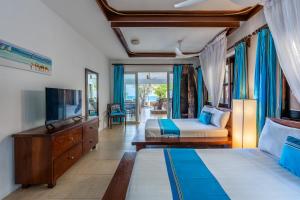 a hotel room with two beds and a television at Tequila Sunrise Pool Cabana-Diani Beach in Diani Beach