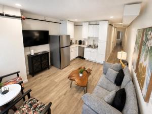 a living room with a couch and a kitchen at Stylish 2BR Retreat - Concrete & Canopy in St. Charles +4 photos