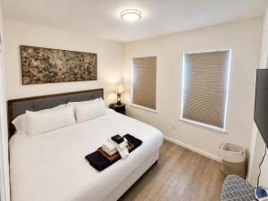 a bedroom with a white bed with two towels on it at Stylish 2BR Retreat - Concrete & Canopy in St. Charles