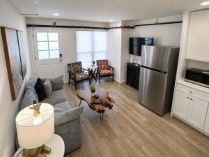 a living room with a couch and a refrigerator at Stylish 2BR Retreat - Concrete & Canopy in St. Charles