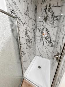 a shower with a glass door and a sink in a bathroom at Stylish 2BR Retreat - Concrete & Canopy in St. Charles