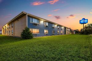a building with a sign in front of a field at AmericInn by Wyndham Albert Lea in Albert Lea