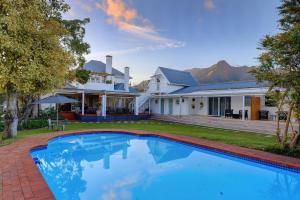 a large swimming pool in front of a house at Whispering Oaks Guest House in George