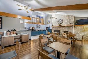 a restaurant with tables and chairs and a fireplace at AmericInn by Wyndham Albert Lea in Albert Lea