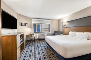a hotel room with a large bed and a desk at AmericInn by Wyndham Albert Lea in Albert Lea