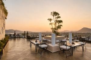 a restaurant with tables and chairs on the roof of a building at Raj Kuber - A Boutique Lake View Hotel in Udaipur
